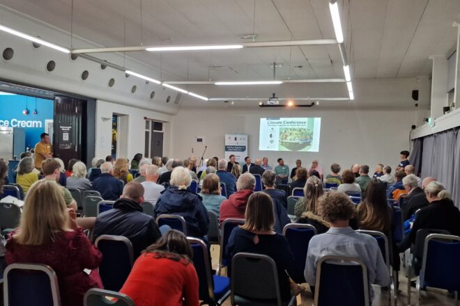 Large room of people watching a slide presentation