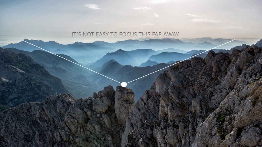 Photo of mountains and the words 'it's not easy to focus this far away'