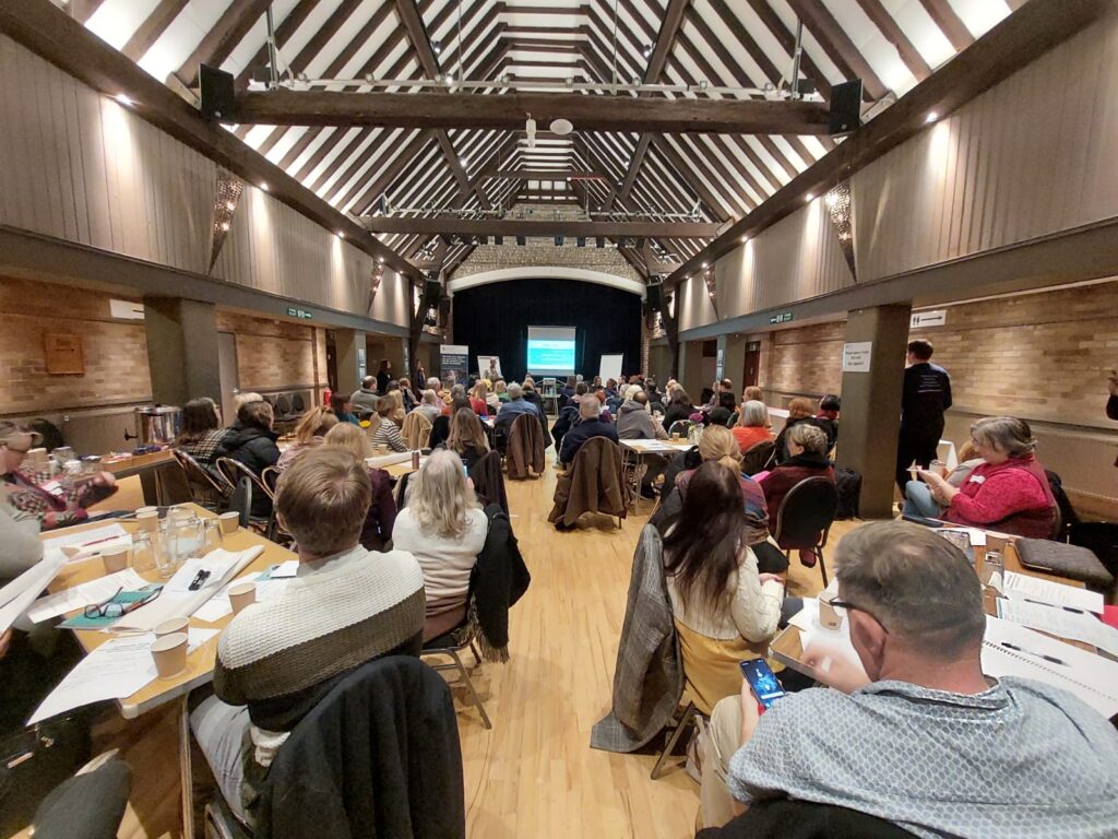 Large hall full of people watching a presentation