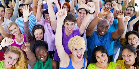 Group of people smiling and waiving hands in the air